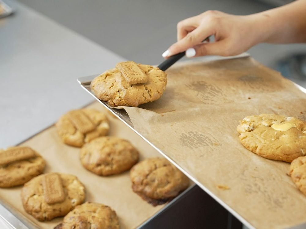 Frische Cookies werden vom Blech gehoben