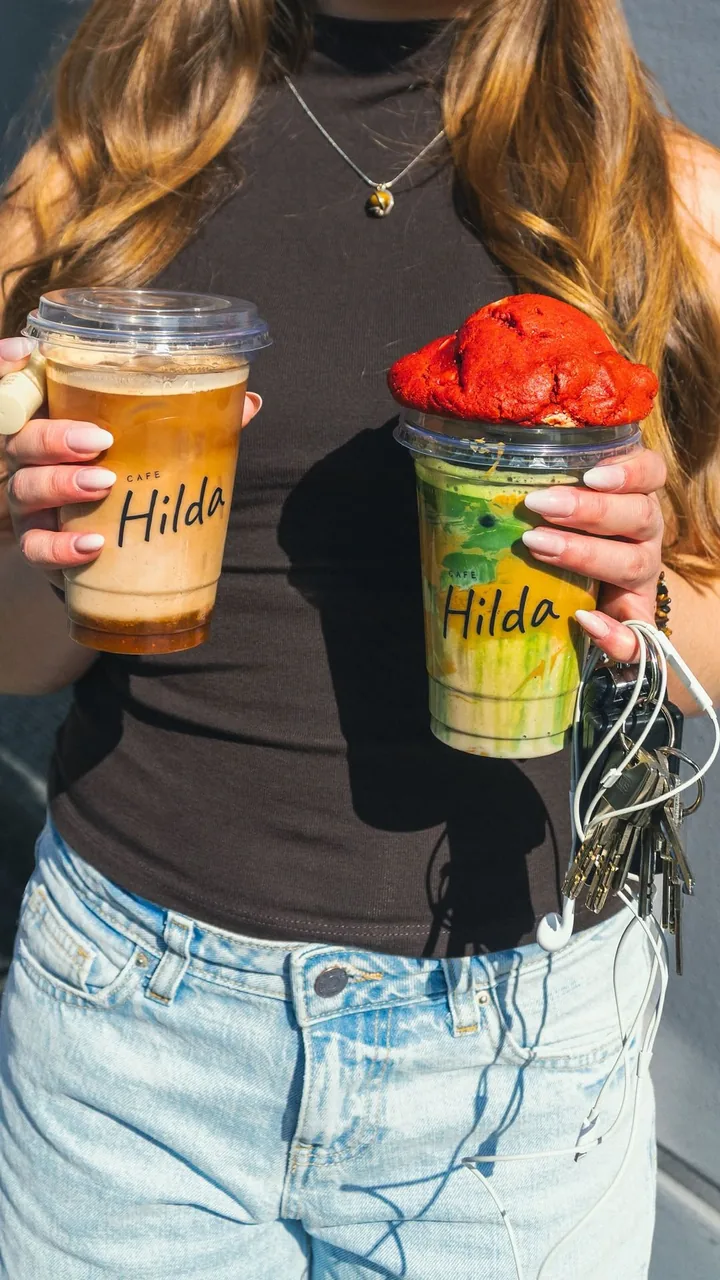 Zwei Iced Drinks in Hilda-Bechern in den Händen